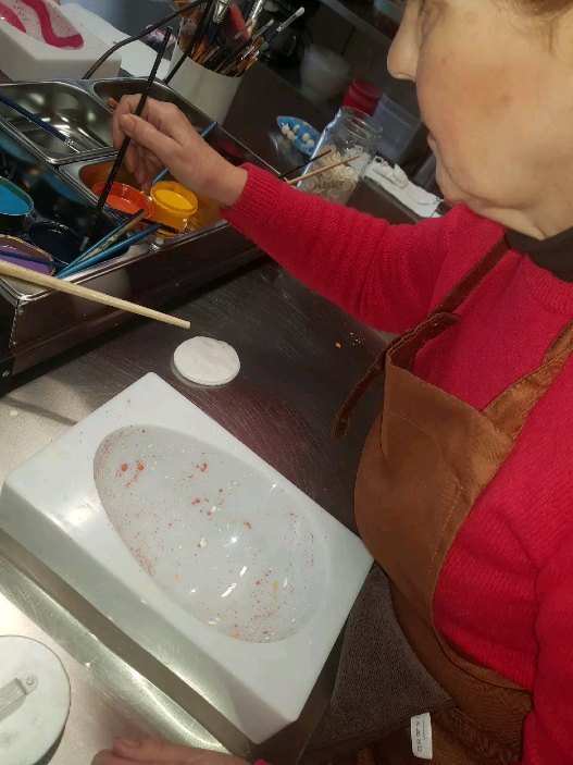 A participant hand-painting a chocolate mould during a small workshop