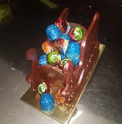 A chocolate sleigh filled with colourful handmade chocolates