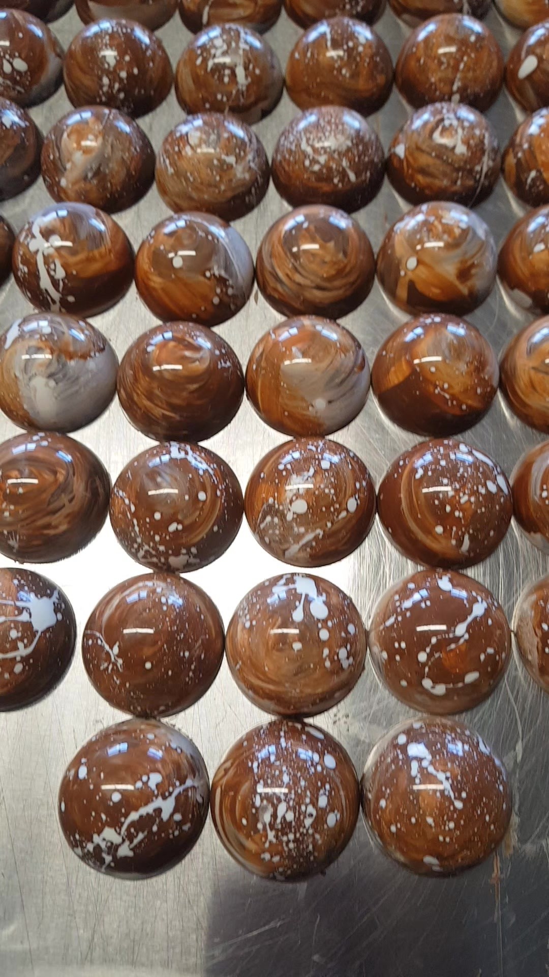 Rows of glossy, hand-painted chocolate bonbons